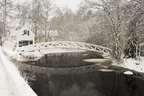 Snow covered arched bridge over water