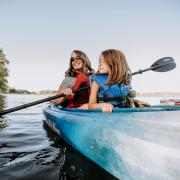 young daughter and mother in blue kayak