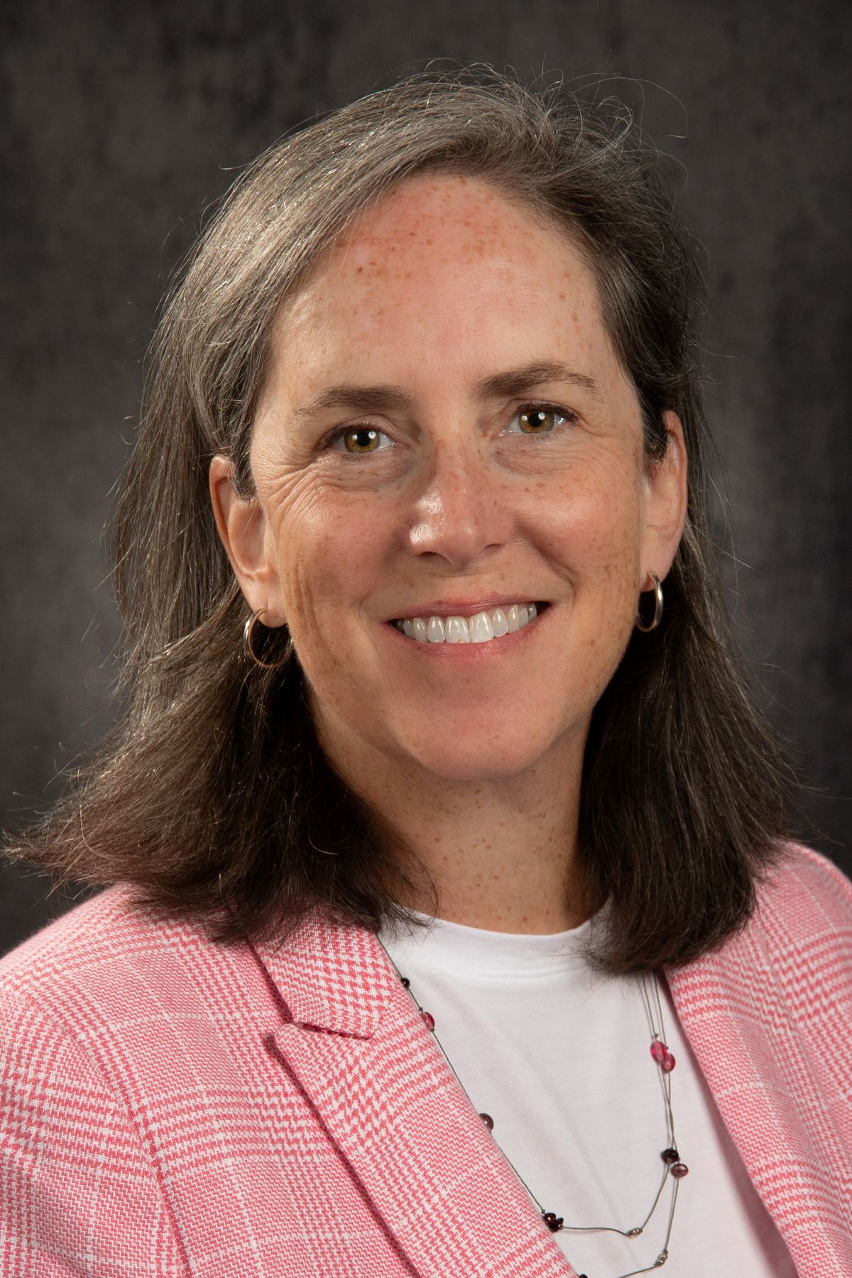Headshot of a woman wearing a pink blazer